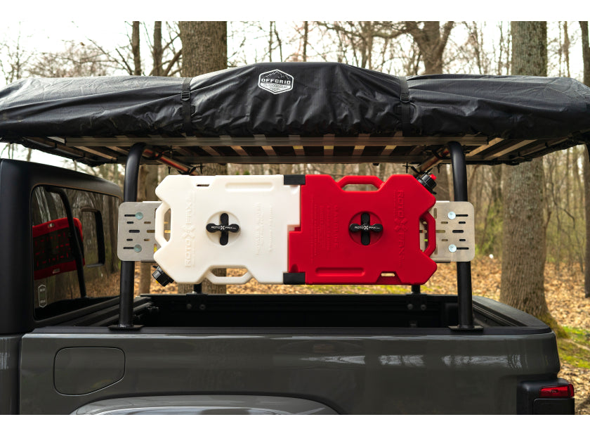 Truck bed rack supporting a rooftop tent with fuel cans mounted on the side