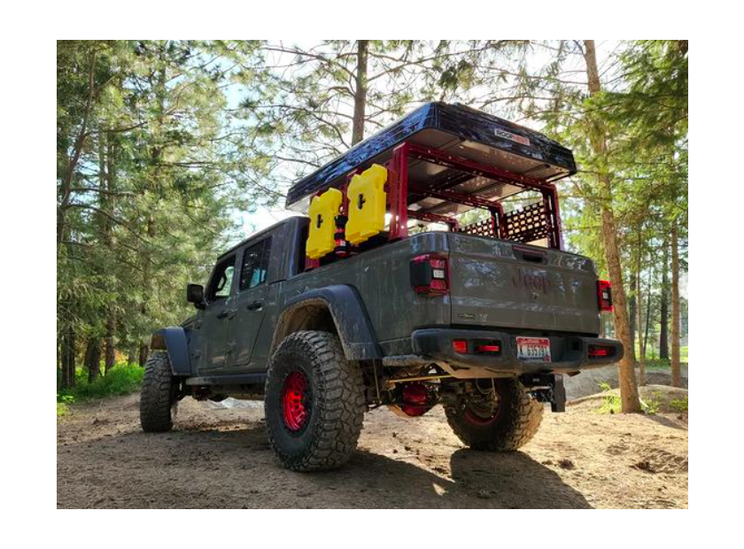Gray lifted Jeep Gladiator with an overland rack in the woods