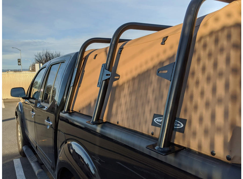Black Nissan Titan with a brown Softopper and tall truck bed bars