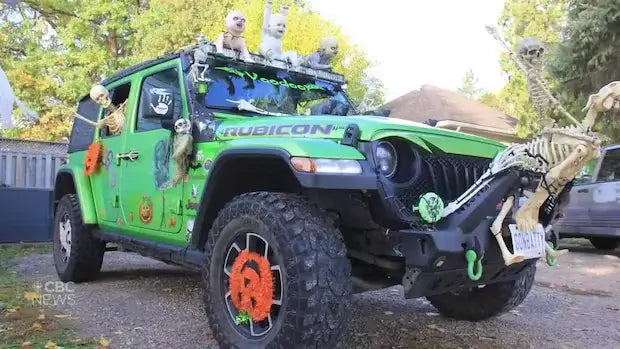 Green Halloween-decorated Jeep Rubicon with orange wheels