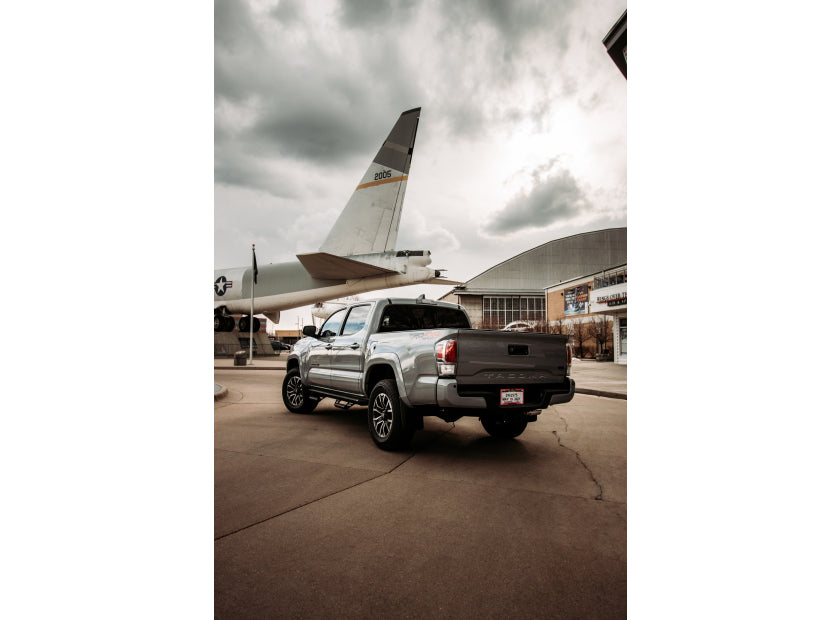 Silver pickup parked in front of an airplane hangar