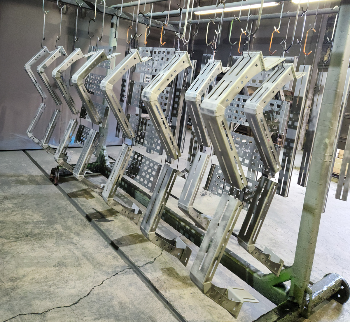 HMOR fabricated rack components hanging together during the powder coating production process